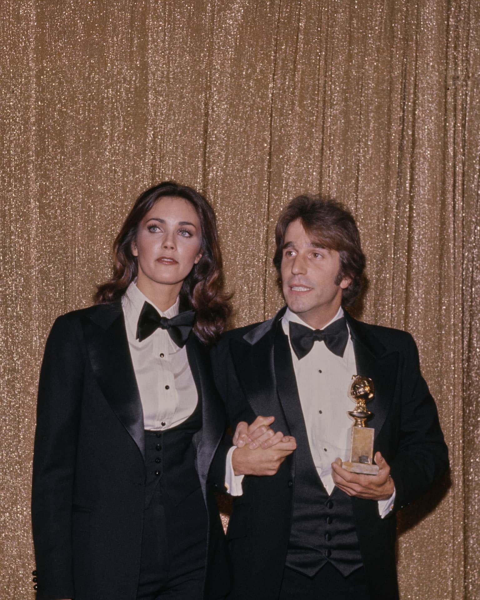 Американская актриса Линда Картер в смокинге и галстуке-бабочке и американский актер Генри Винклер, также в смокинге и галстуке-бабочке, в пресс-зале 34-й церемонии вручения премии «Золотой глобус» в Беверли-Хиллз, Калифорния, 29 января 1977 года | Getty Images